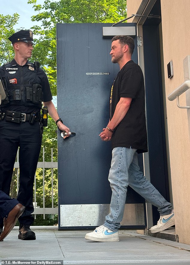 A bleary-eyed Justin was seen emerging from the Hamptons police station in handcuffs