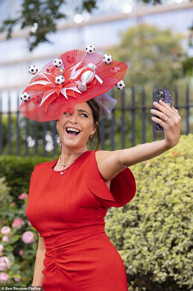 Lisa complemented the eccentric hat with a red mididress which had ruched detailing at the waist and appeared in high spirits as she posed for selfies