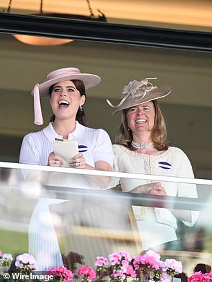 The royal held her race card aloft as she watched on with Lady Laura Meade