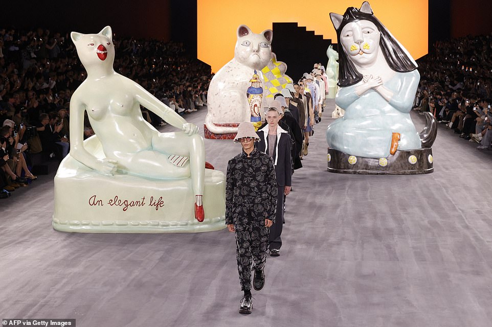 Models walked the runway surrounded by giant cat shaped statues