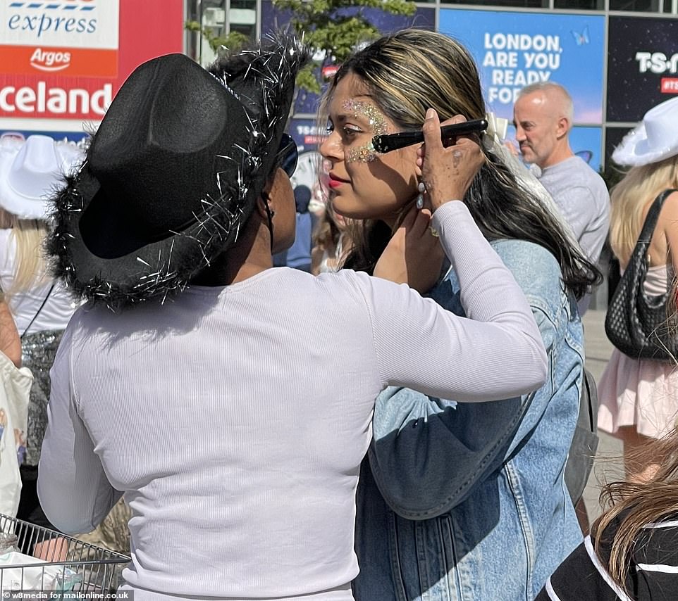 A fan gets glittered in preparation for the Eras Tour arriving for the first time in London on Friday night