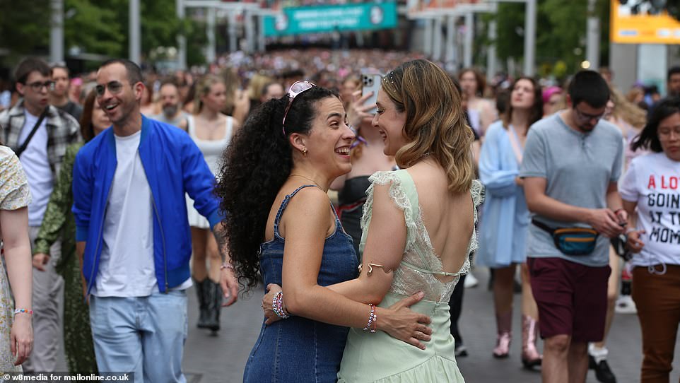 Two girls hug as they approach Wembley Stadium ahead of the Taylor Swift concert