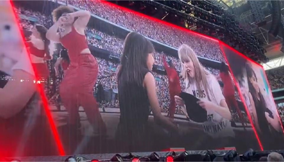 Taylor gives her hat to a fan during the first London concert of The Eras Tour at Wembley