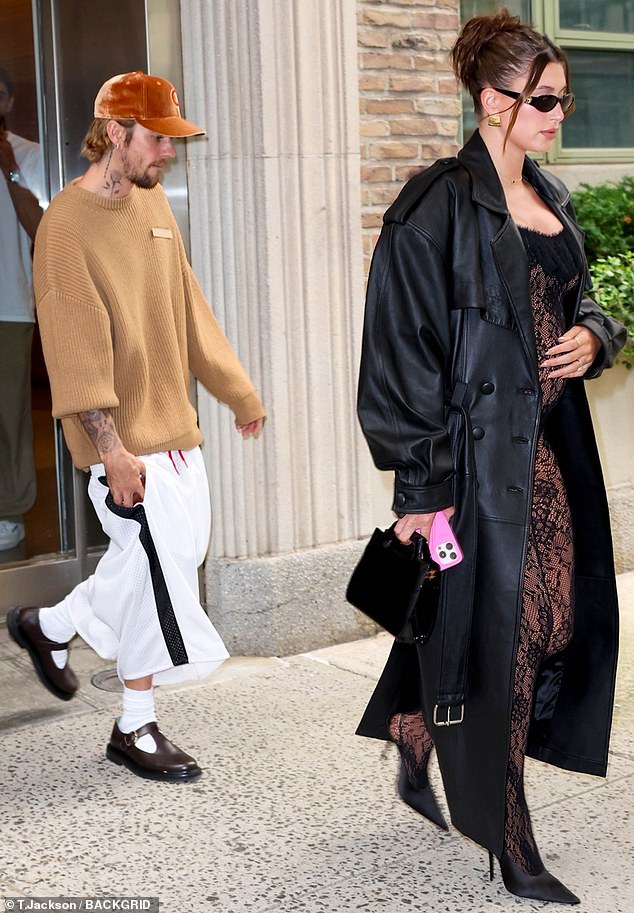 Expertly balancing on high-heeled sandals, the expectant mother added to her look by wrapping herself in a long black leather overcoat