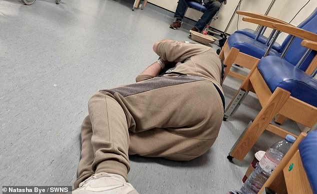 Pictured: A man is sleeping on the floor in A&E after waiting 45 hours for a bed at William Harvey Hospital in Ashford, Kent.