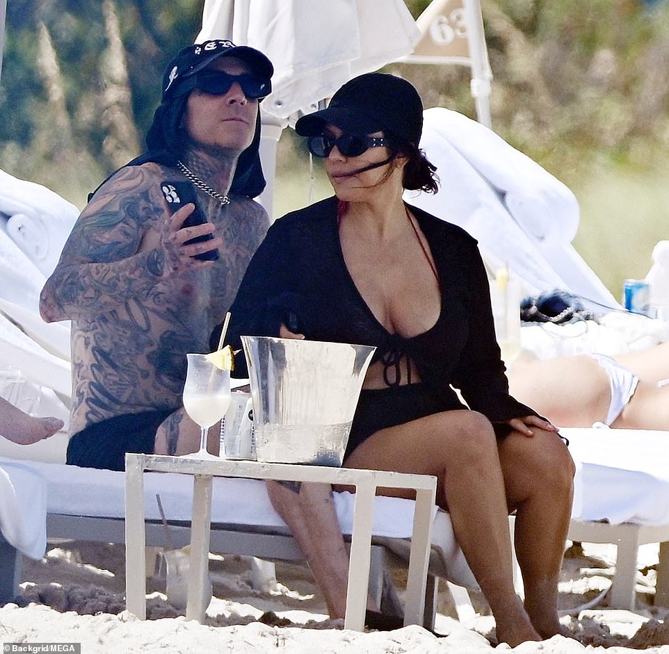 The Dash Dolls star also had netted black flat Mary Janes shoes on as she walked on the hot sand