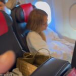 PICTURED: Jennifer Lopez settles in for her economy flight to Paris wearing a track suit as diva saves money amid ongoing Ben Affleck divorce rumours and after tour cancellation