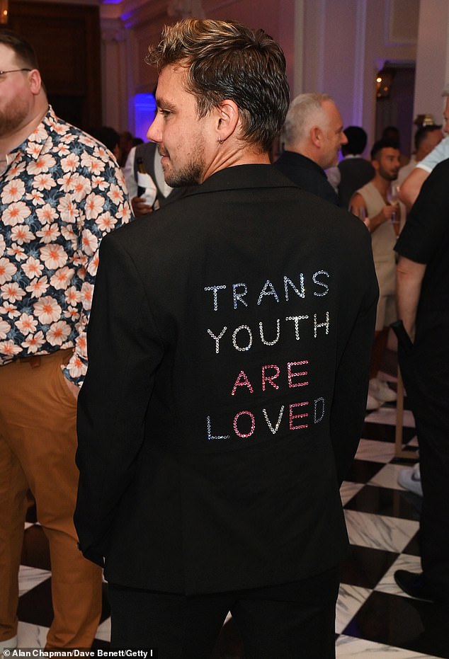 He turned around to show his blazer featured bejewelled lettering on the back that read: 'Trans Youth Are Loved'