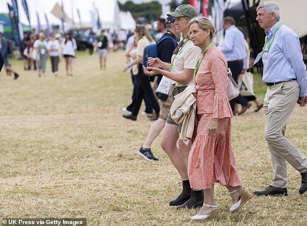 The Duchess of Edinburgh walked across sunlit grass in a cream-coloured dress and chatted to a festival worker