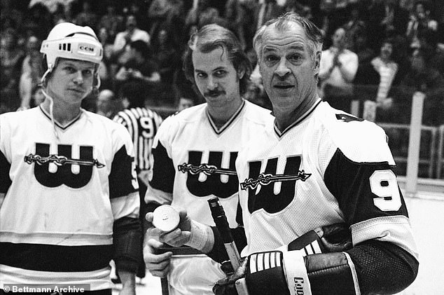 A little fatherly advice from hockey great Gordie Howe as he accepts the gold puck from his sons and teammates Mark and Marty Howe (center) in honor of his 1,000th goal