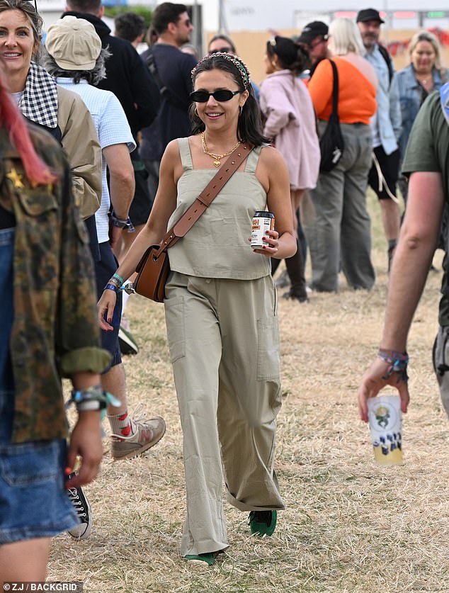 Bel teamed her look with green trainers and tan cross-body bag, finishing her look with chic black sunglasses