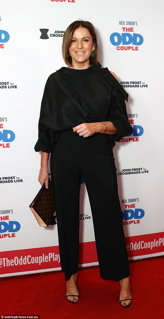 Sporting a very discreet makeup look, the Breakfast Show presenter tucked a dressy cold-shoulder top into a pair of straight-legged black slacks