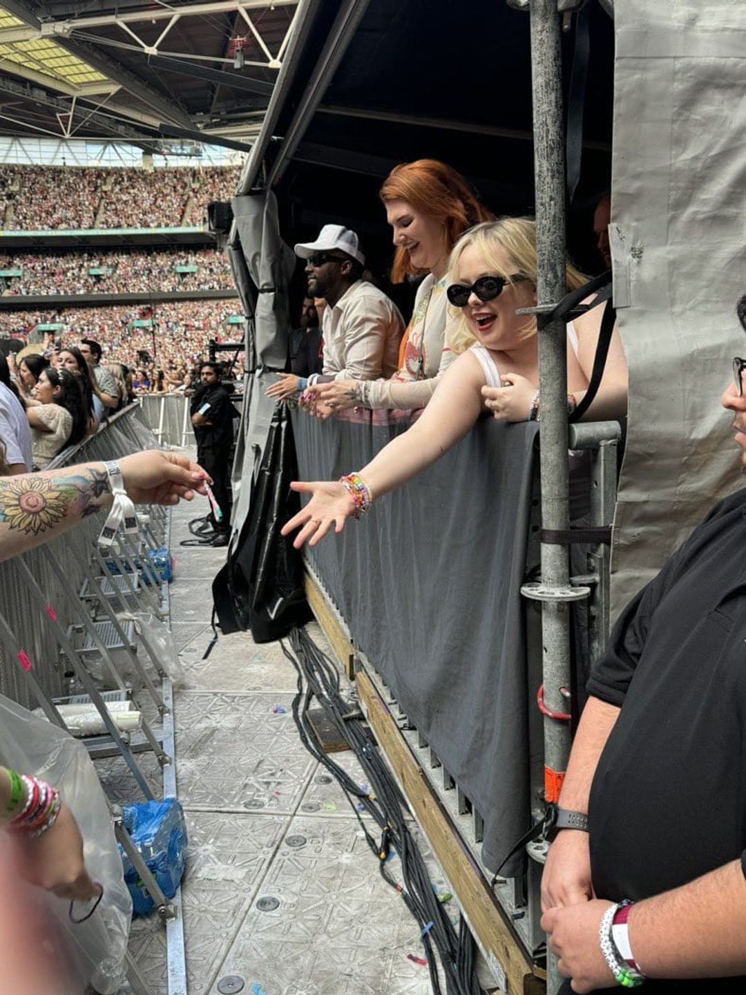 Nicola Coughlan reaches out to receive a bracelet at Taylor Swift's concert