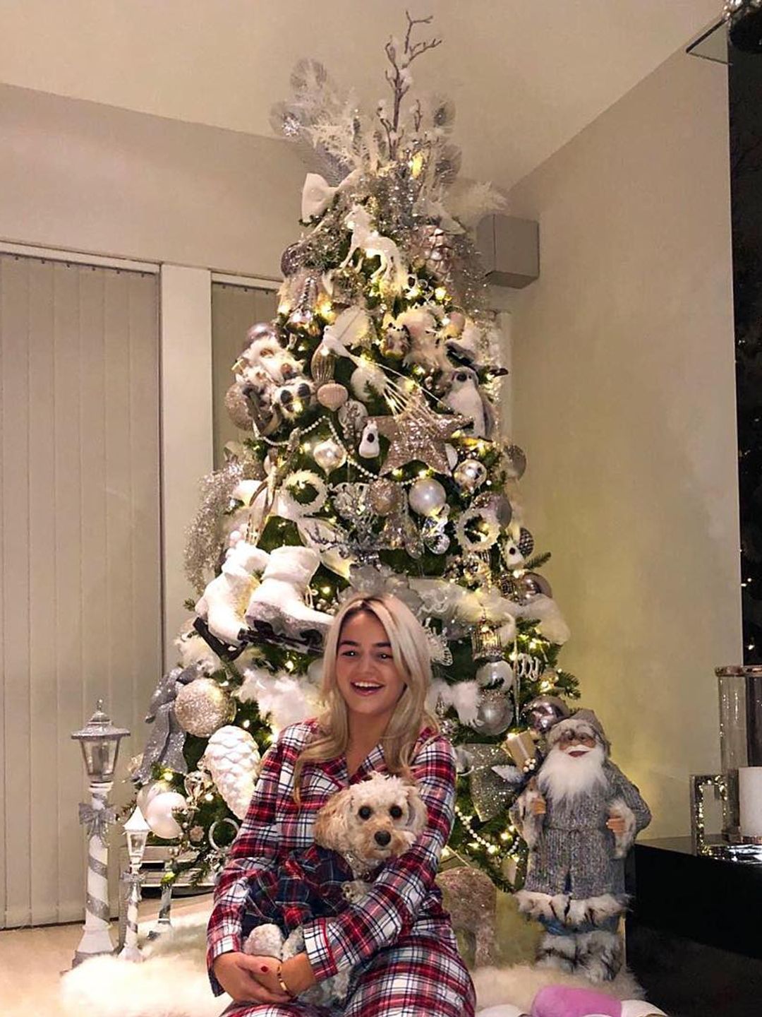 Woman posing in front of a decorated Christmas tree 