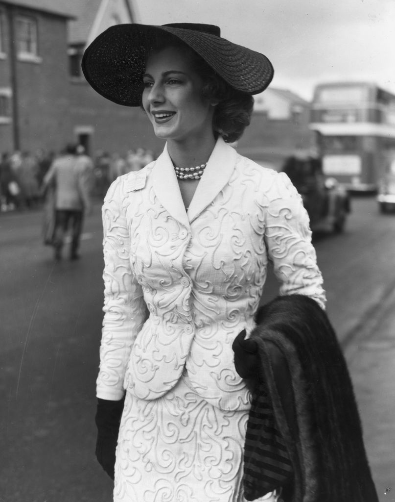 16 June 1953: On the first day of the Royal Ascot meeting, model Fiona Campbell Walter (later Baroness von Thyssen) wore a black straw hat, a white corded suit and a pearl necklace and carried a fur stole. (Photo: Keystone/Getty Images)