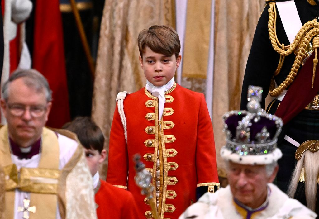 Pages of Honour carrying Prince George of Wales and Britain’s King Charles III wearing the Imperial State Crown leave Westminster Abbey after the coronation ceremony in central London on May 6, 2023. 