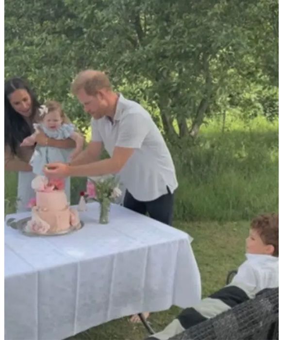 Prince Harry, Meghan Markle, Prince Archie watching Princess Lily blow out the candles