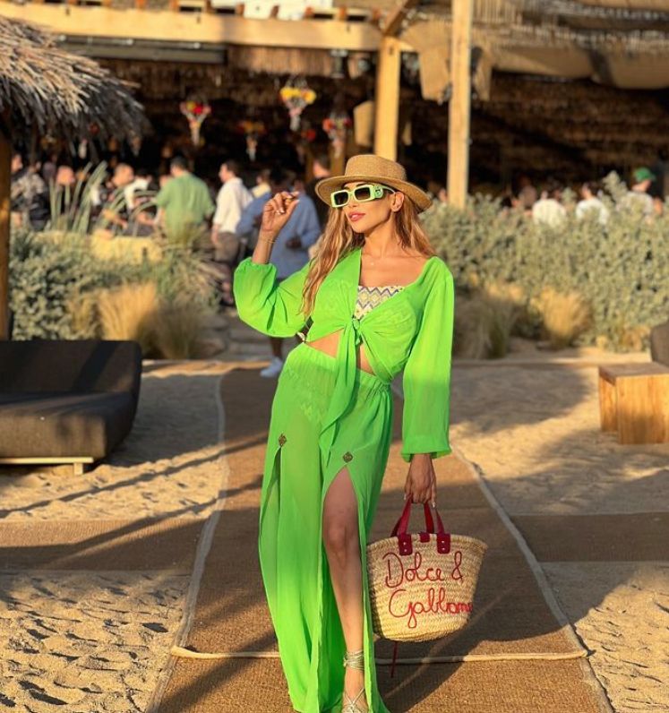 Farah El Kadi in a green dress in front of a beachside restaurant