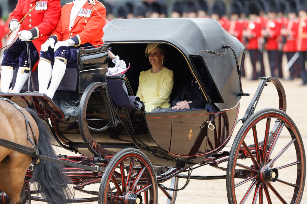 Duchess Sophie in a yellow dress riding in a royal carriage