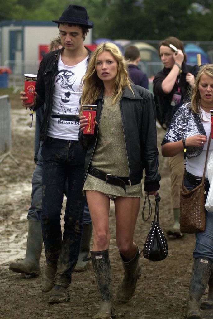    Kate Moss attends Glastonbury in 2005 wearing a golden dress, wellington boots and a leather jacket