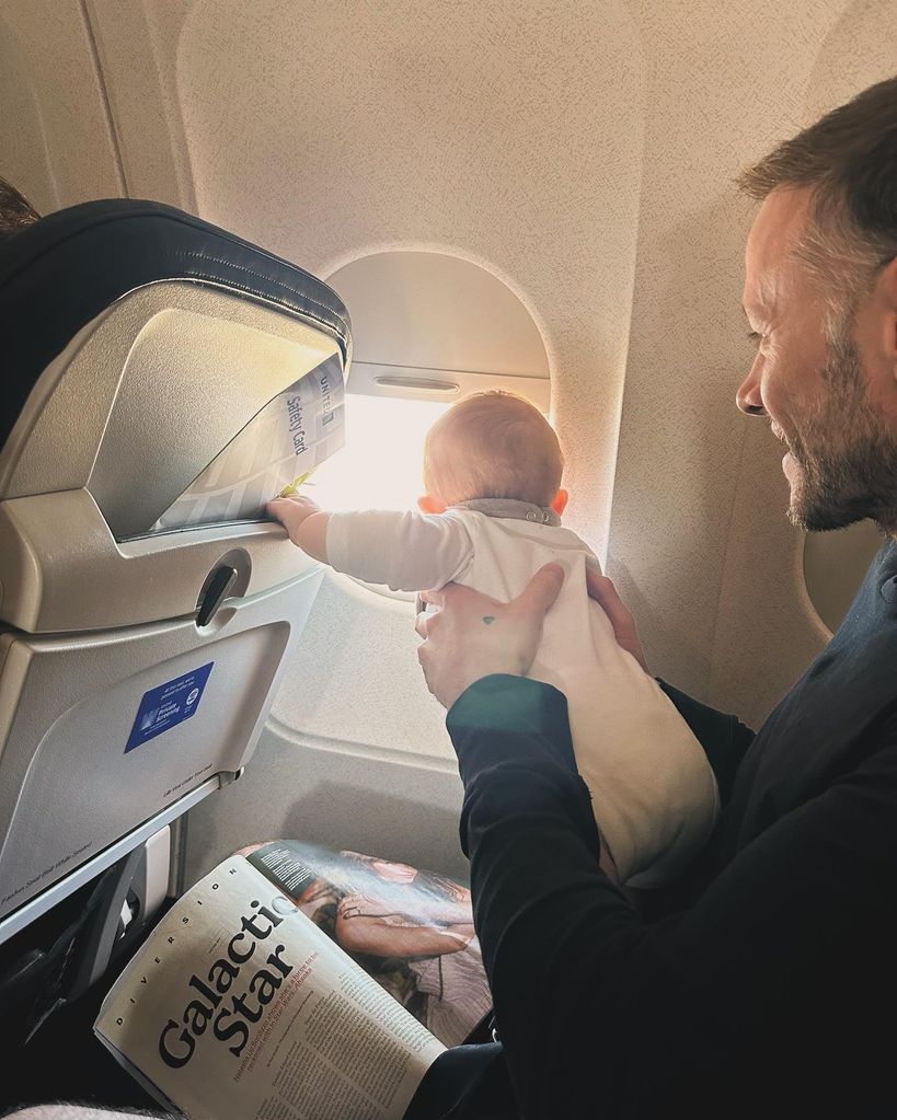 Father holding daughter in his arms on plane