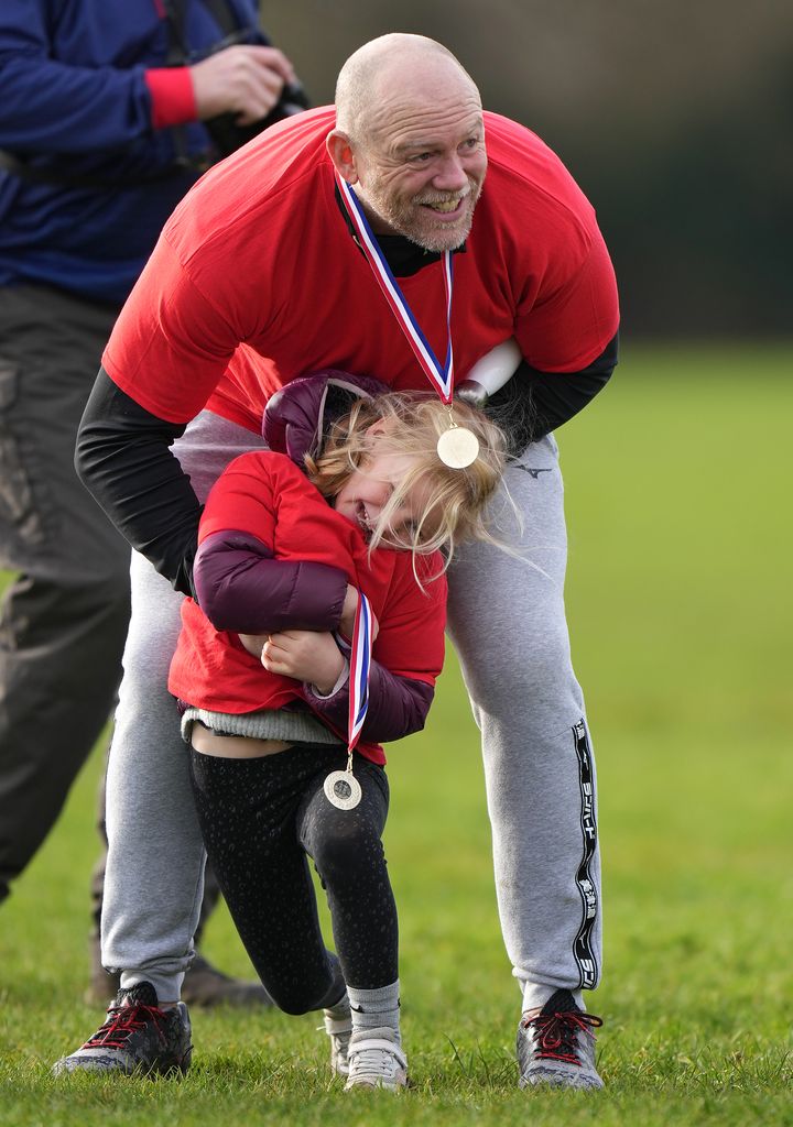 Mike Tindall in a red charity shirt hugs daughter Lena Tindall during the Rugby for Heroes Fun Run  