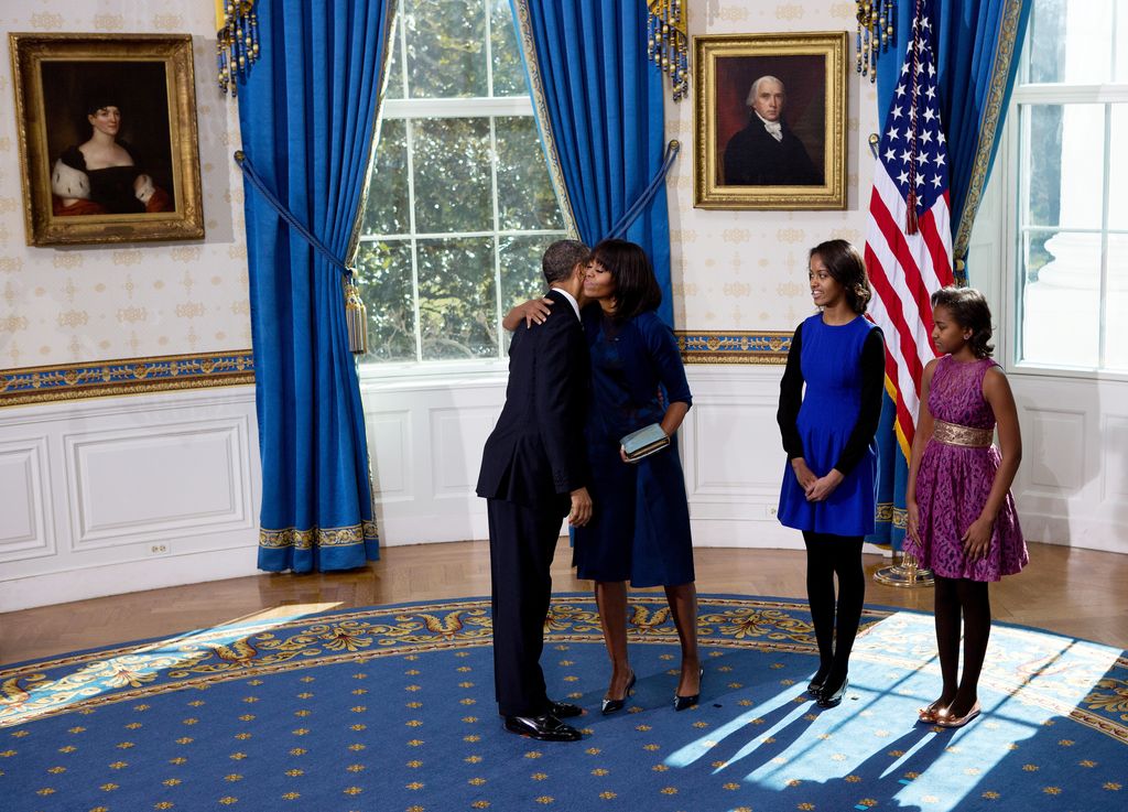 US President Barack Obama embraces First Lady Michelle Obama (second from left) after taking the oath of office in the Blue Room of the White House in Washington, DC, January 20, 2013, while daughters Malia (center) and Sasha look on. Obama and US Vice President Joe Biden were officially sworn in a day before the formal swearing-in.