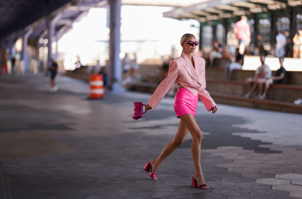 Leonie Hahn is tonal outfit goals in her neon pink mini skirt, baby pink blazer, pink Balenciaga hourglass bag and matching metallic heels at New York Fashion Week