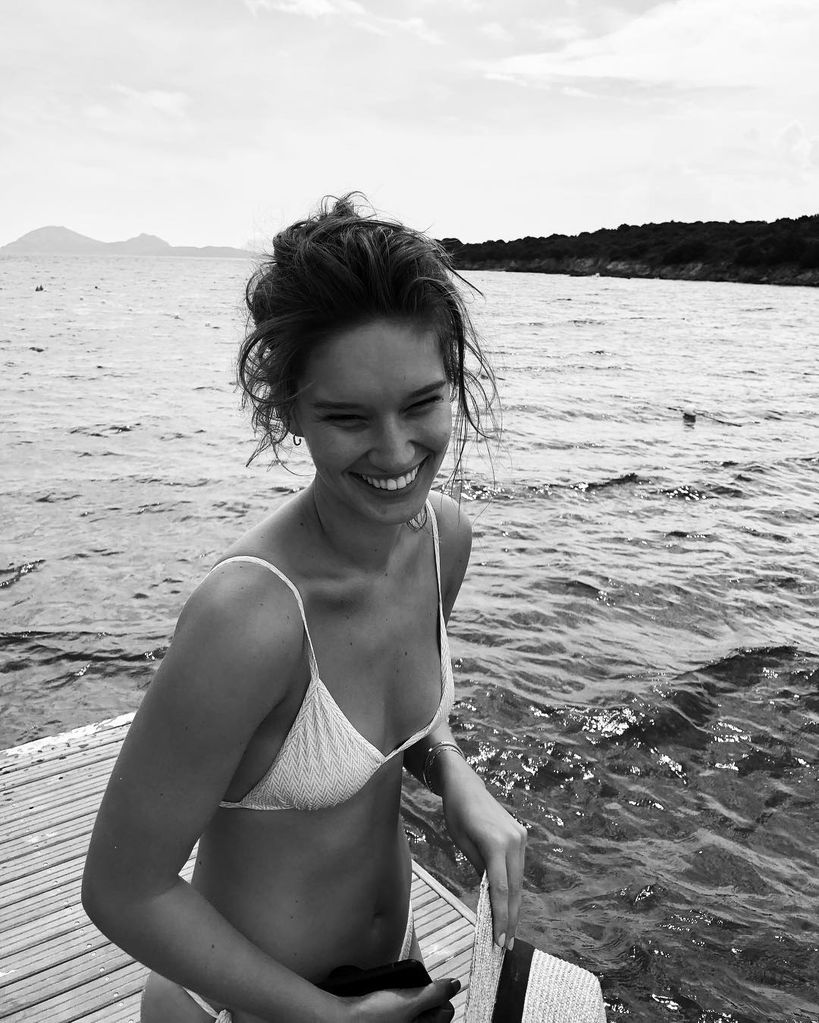 Black and white photo of a woman wearing a bikini at the beach