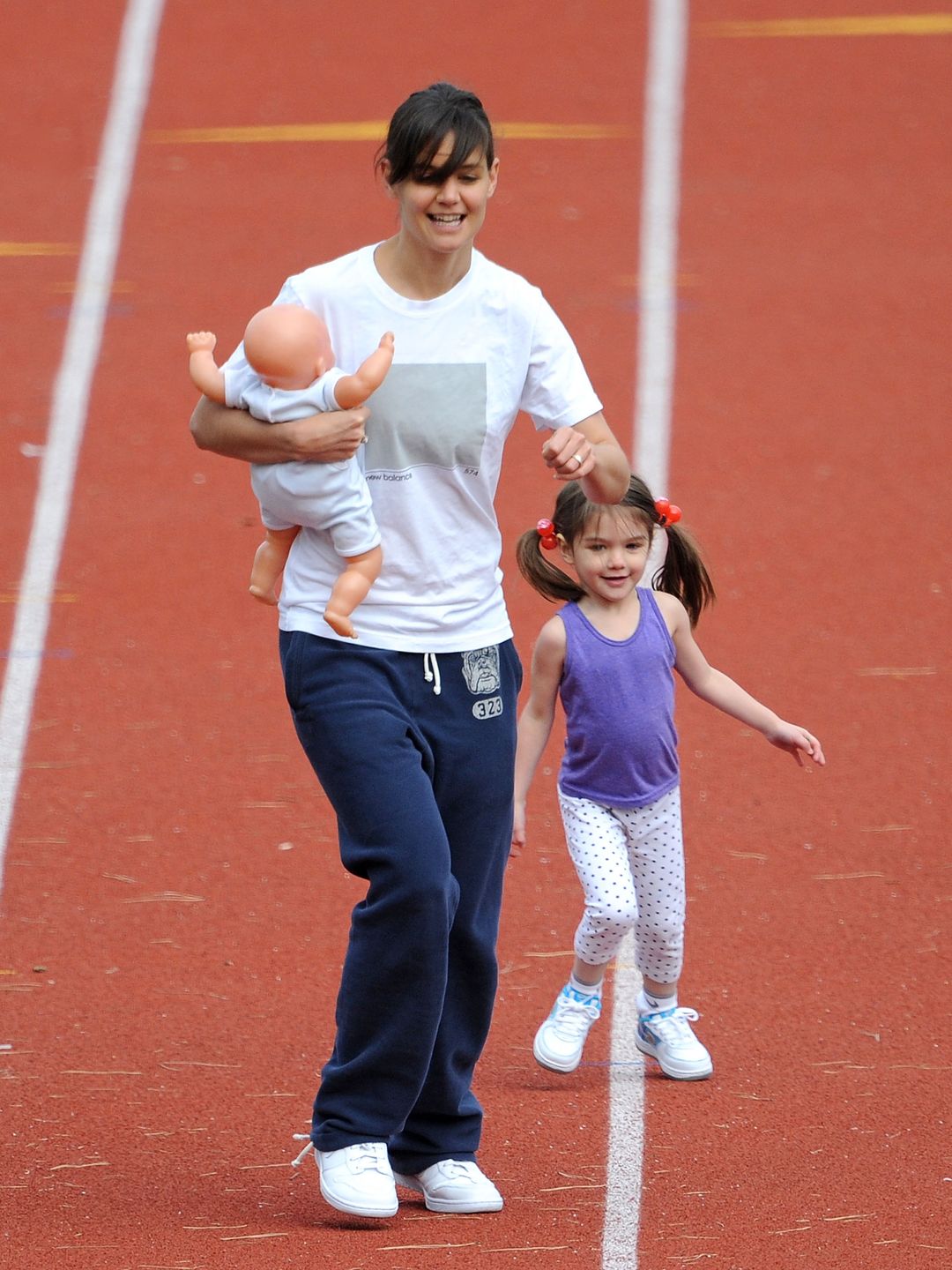 Katie Holmes and her daughter Suri Cruise run on a track field on October 12, 2009 in Boston, Massachusetts.