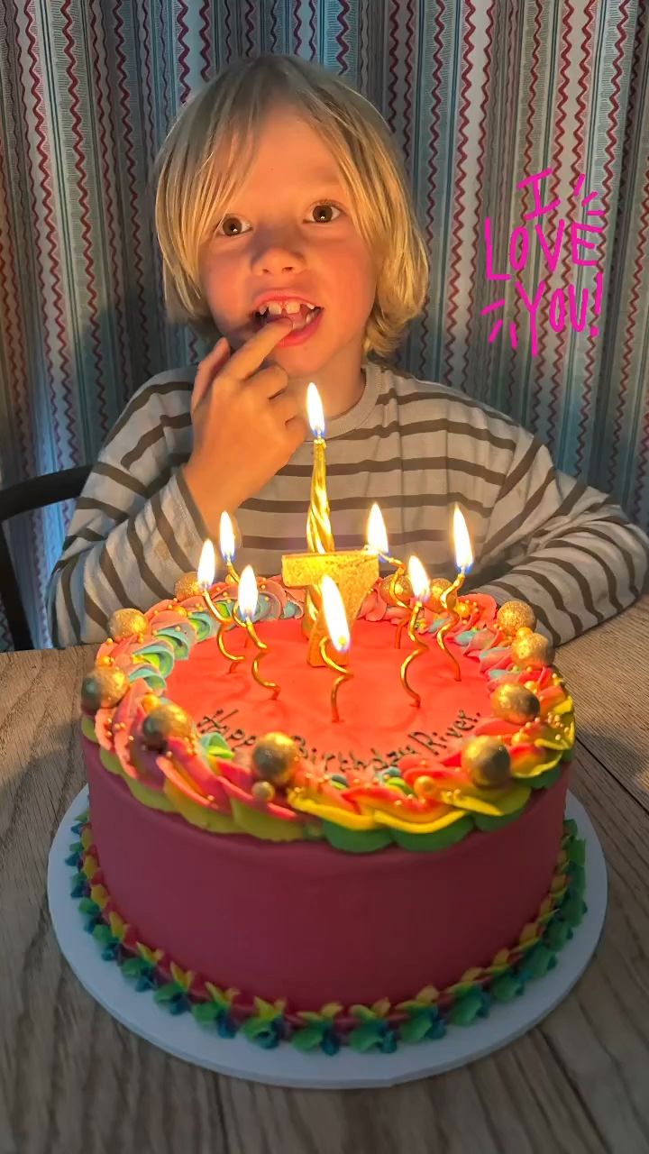 River Oliver behind the pink and rainbow birthday cake