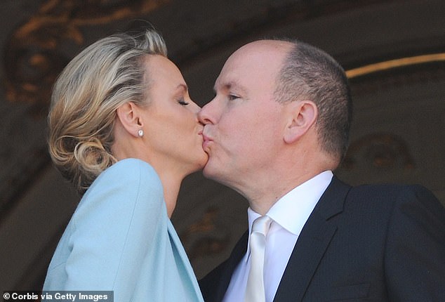 Charlene and Albert share an awkward kiss on the balcony of the Prince's Palace after the civil ceremony which made them husband and wife, July 1, 2011