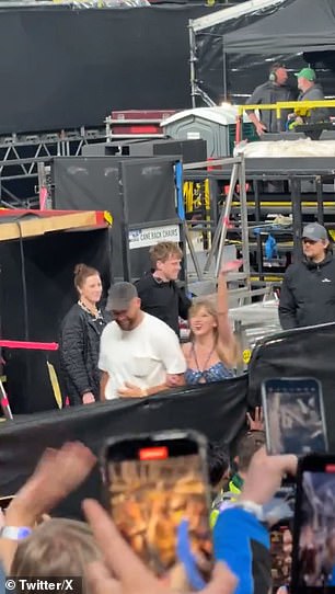 Taylor and Travis wave to the crowd as they walk off stage hand-in-hand in Dublin