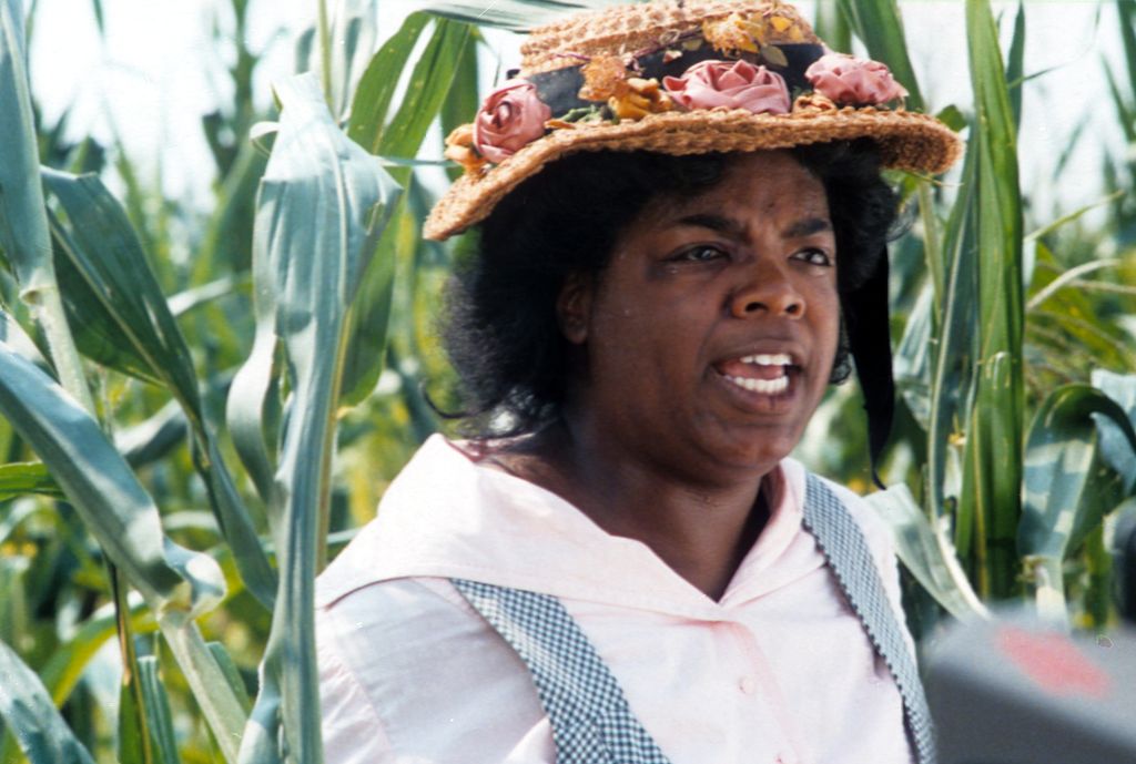 Oprah Winfrey walks through a cornfield wearing a hat in a scene from the 1985 film 'The Color Purple.' (Photo: Warner Bros./Getty Images)