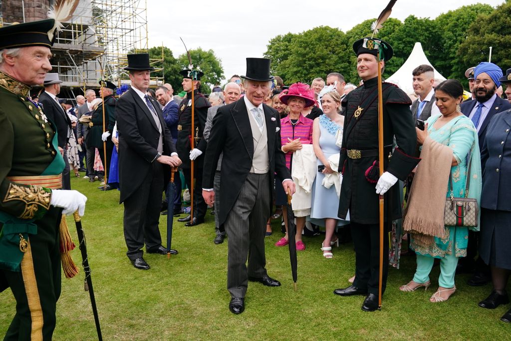 King Charles wearing a top hat at a garden party